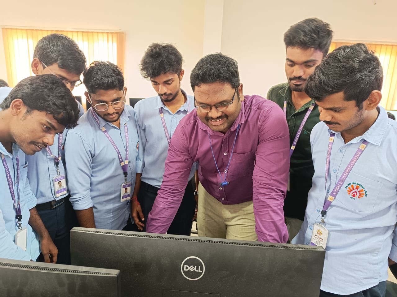 MRL trainer guiding a group of engineering students at a computer during a lab session