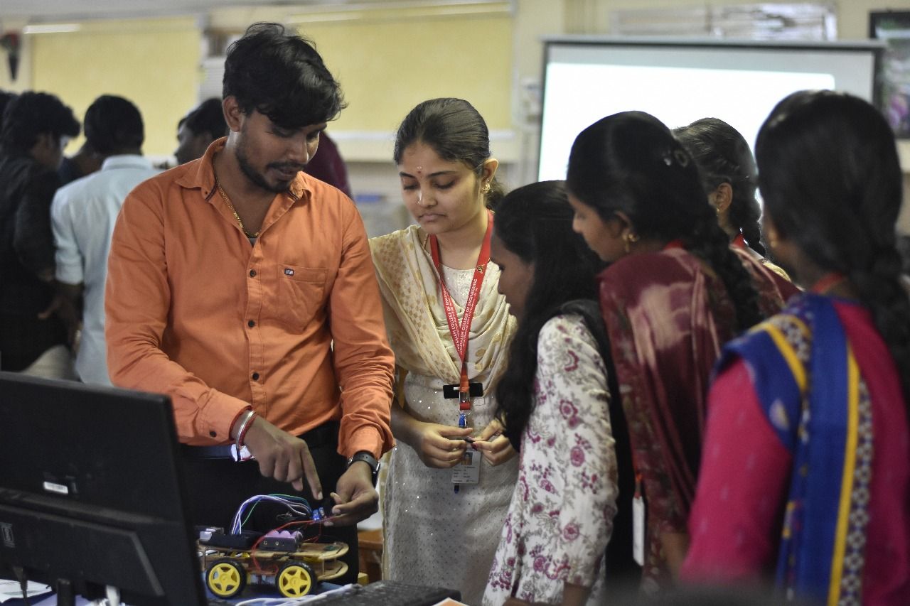 Trainer showing students the wiring of a robot car kit during an IoT and robotics workshop