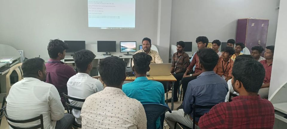 Trainer leading a small-group discussion with students in a computer lab